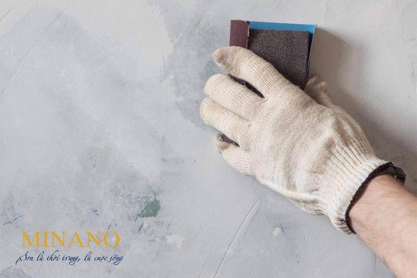Dùng giấy nhám để chà sạch bề mặt tường